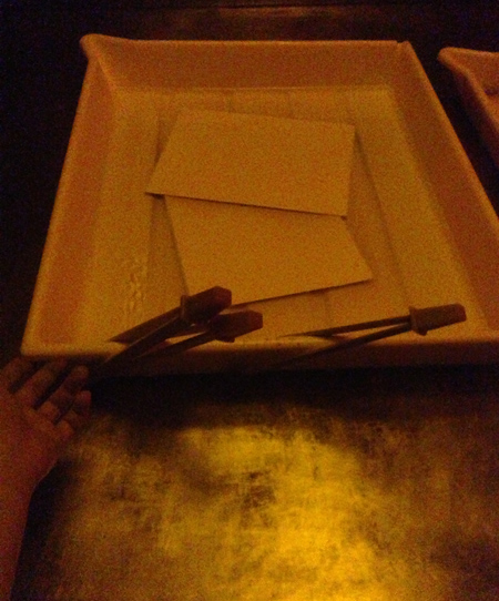 darkroom: agitating prints in the fixer bath