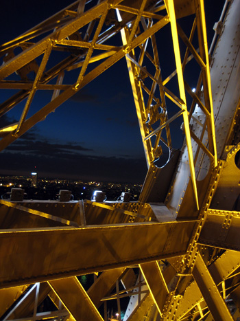 climbing down from the eiffel tower, peeking through its frame